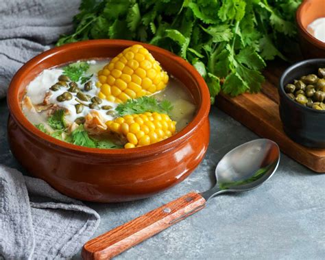 ¡Ajiaco Santafereño: Una Sinfonía de Sabores Cremosos y Especias Apicantes que Encantarán tu Paladar!